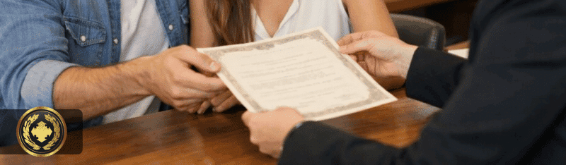 Um casal sorridente recebe uma certidão de uma atendente em um cartório, em um ambiente organizado e bem iluminado. A cena transmite um momento importante e positivo, com foco nas expressões naturais e na entrega do documento.